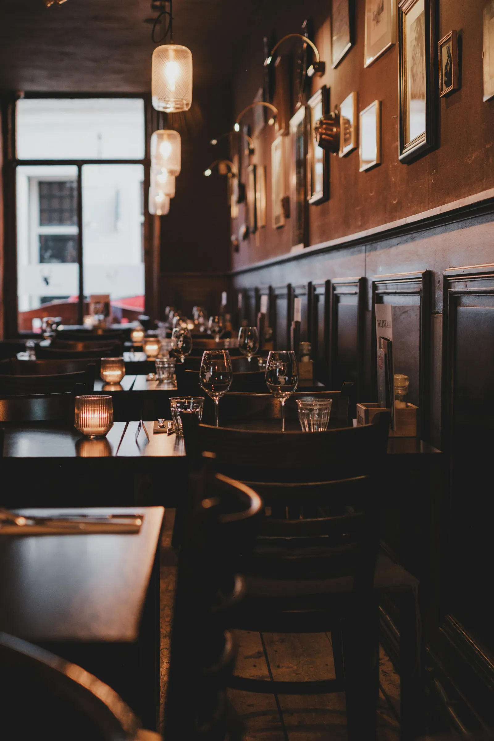 An empty dining room with lamps lit before service