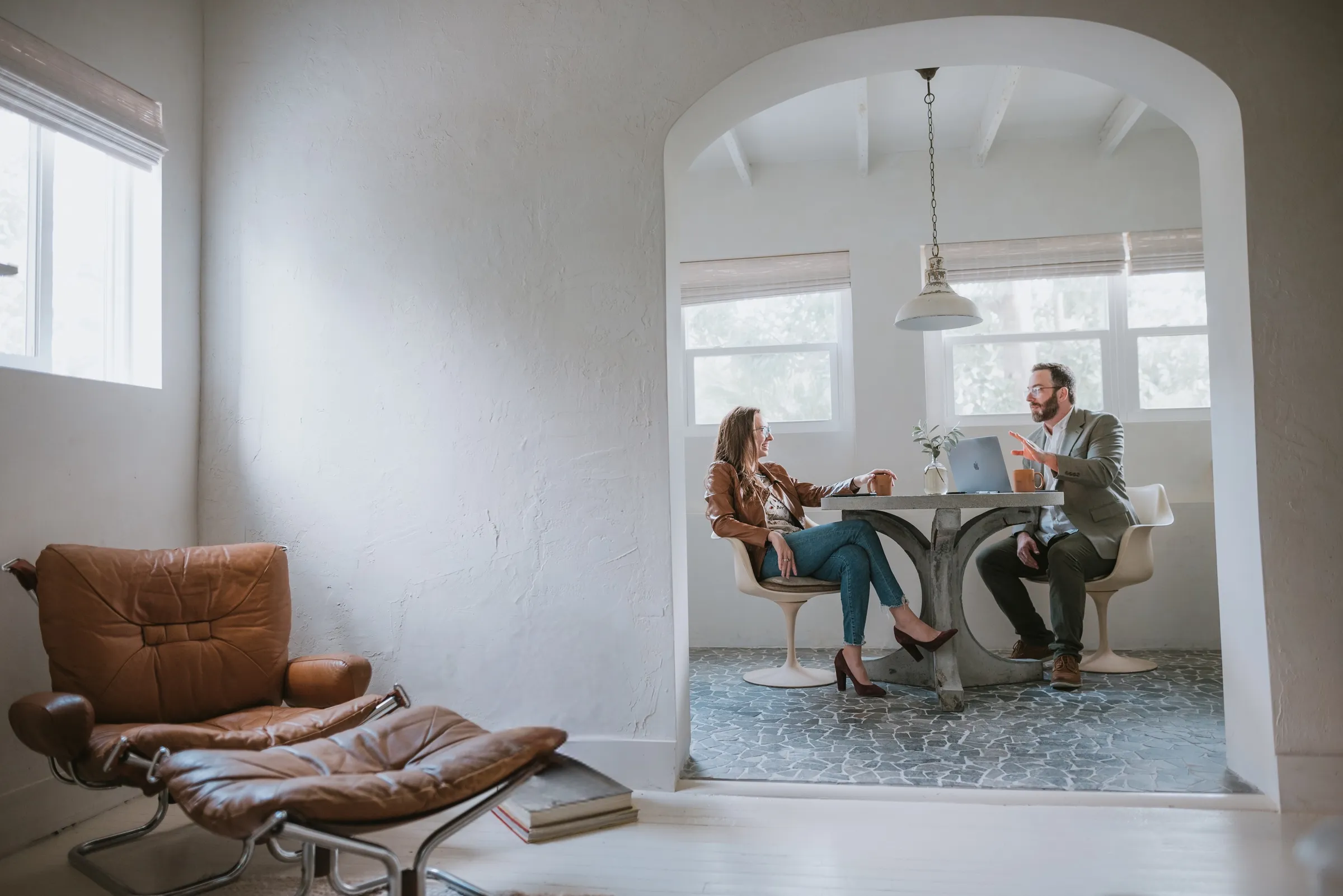 David and Rebekah, GoodBibee’s founders, talking over coffee at a table in a white arched room